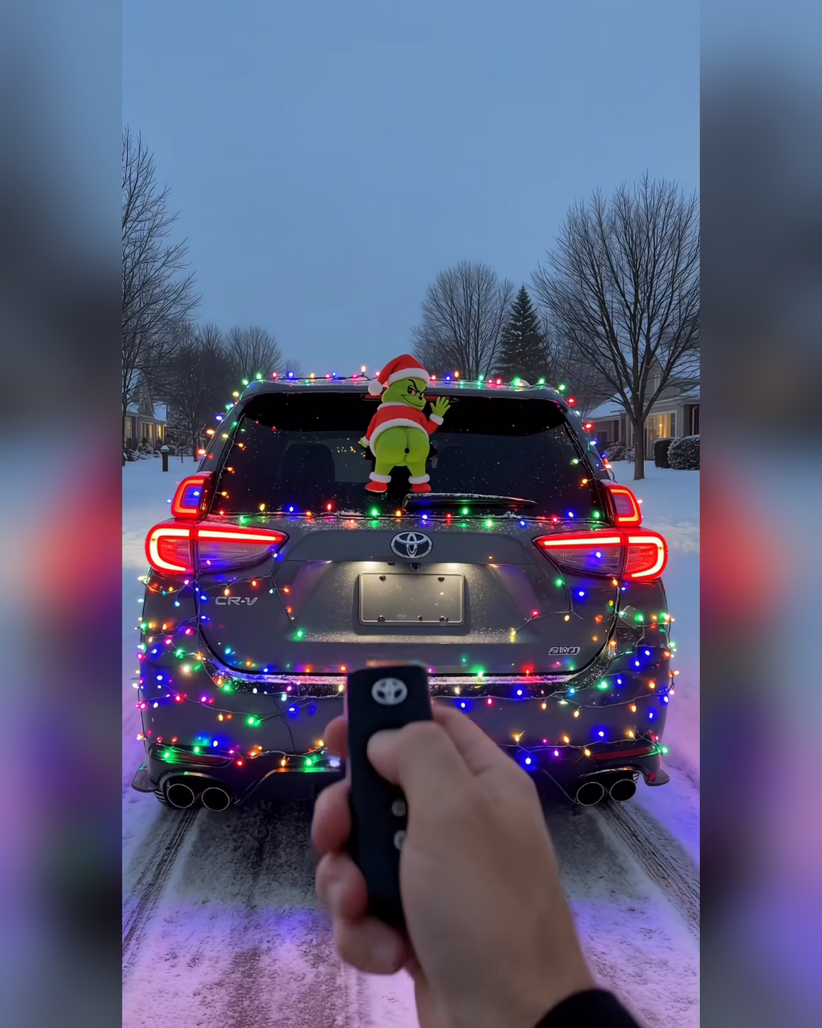 GrinchMist on a Christmas-lights car, remote in hand
