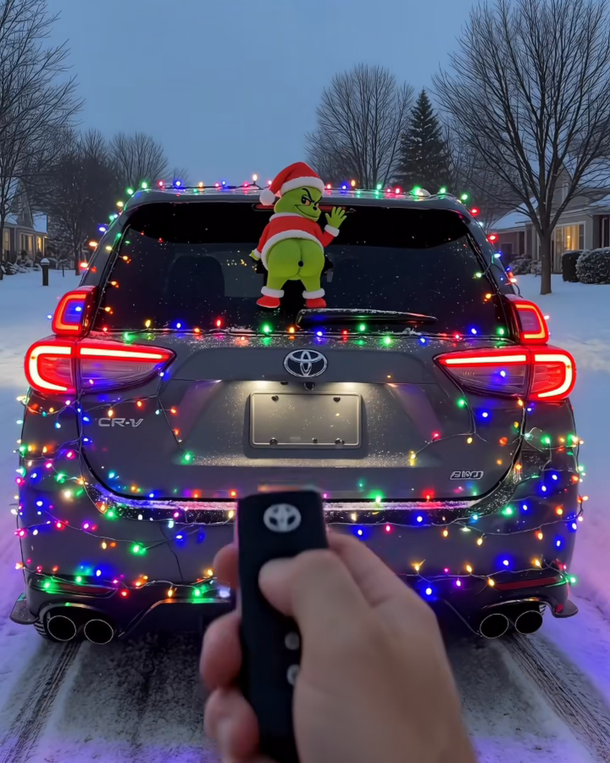 GrinchMist on a Christmas-lights car, remote in hand