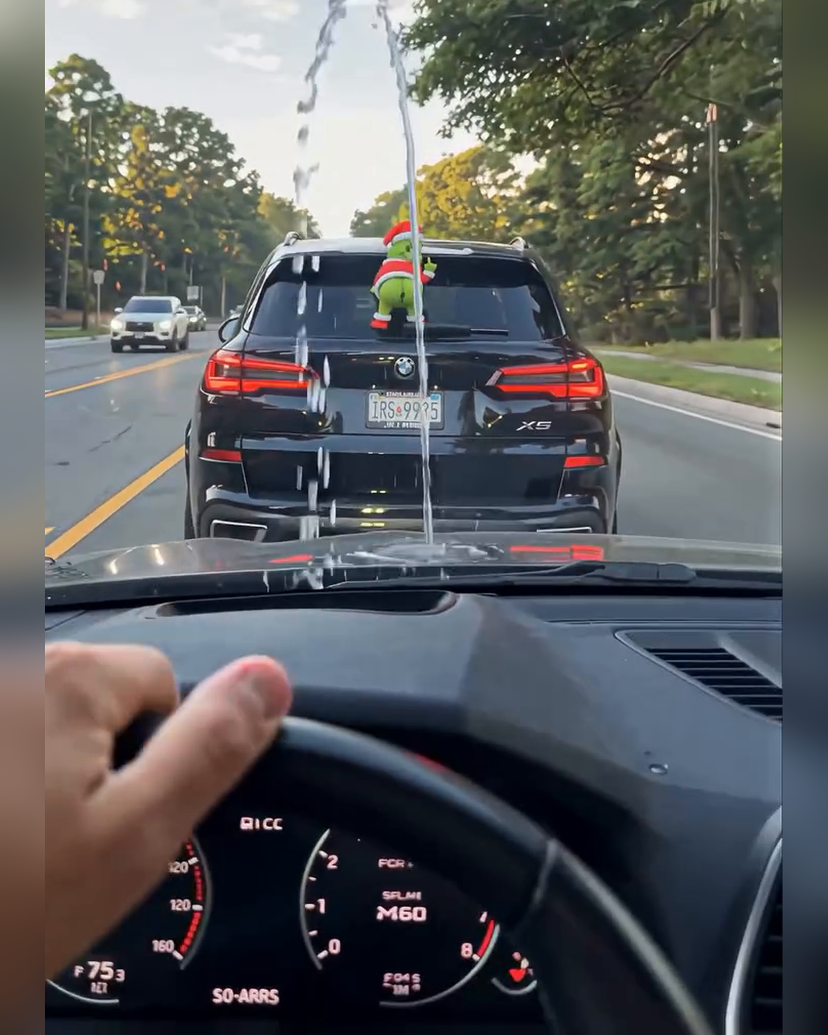 GrinchMist sprayer spraying water at the car behind